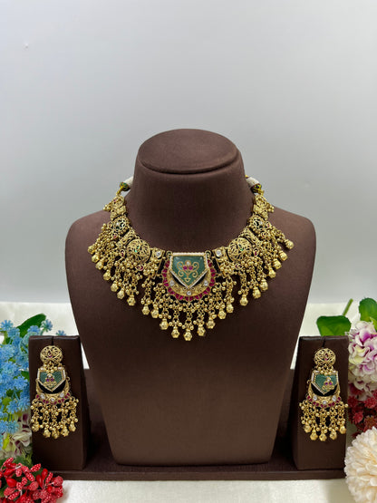 Gold necklace and earrings set on a brown mannequin with a gray background