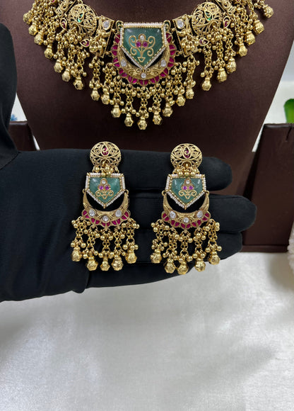 Gold jewelry set with earrings and a necklace on a mannequin.